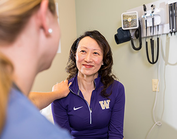 Care provider with their hand on a patient's shoulder.