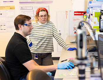 Two individuals in a lab looking at a computer screen.