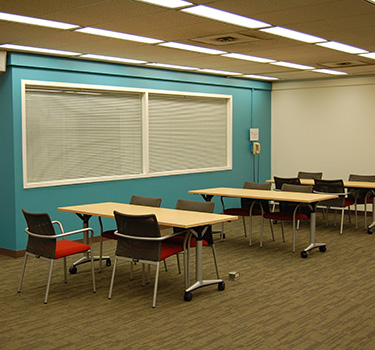 Open area with tables with two to four chairs each.