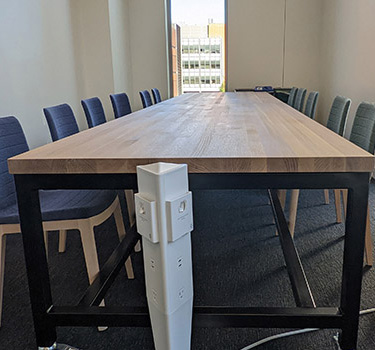 Long conference table with chars in the Douglas Fir area