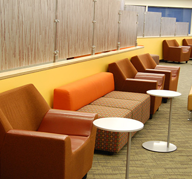 Large open area with cushioned chairs and multi seating areas with a variety of tables.