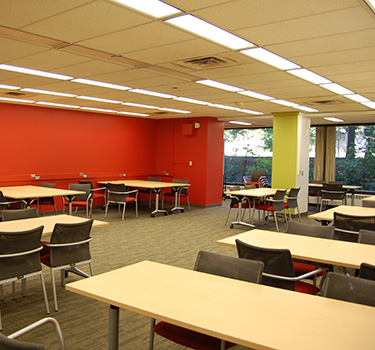 Large open area with tables surrounded by four chairs each.