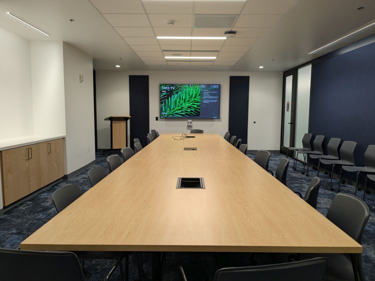 Photo of Room T351 showing a long conference table, TV and camera, and offices chairs
