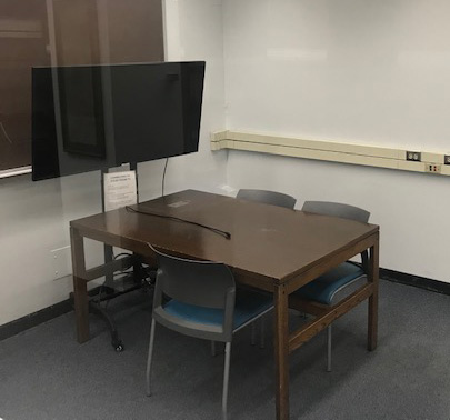 Study room with two tables with chairs and a tv monitor